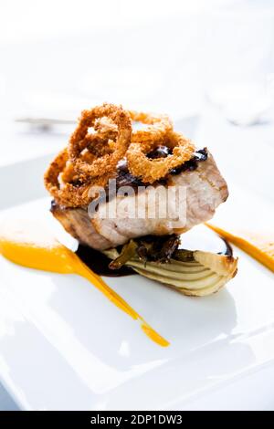 Gegrilltes Fleisch mit Zwiebelringen auf dem Teller Stockfoto