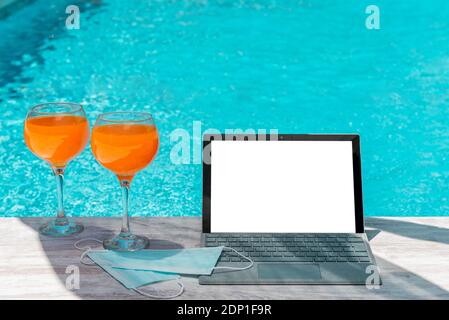 Orangensaft Computer und covid-19 Coronavirus Schutzmasken in der Pool Stockfoto