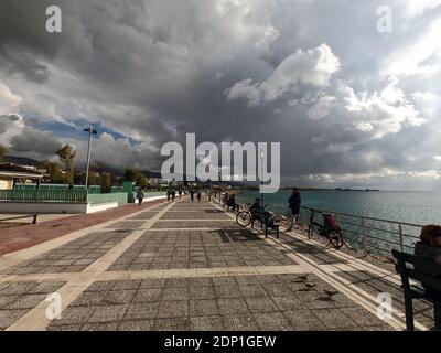 Menschen genießen die Aussicht am Meer an einem hellen Dezembertag in Alimos, in der Nähe von Athen, Griechenland Stockfoto