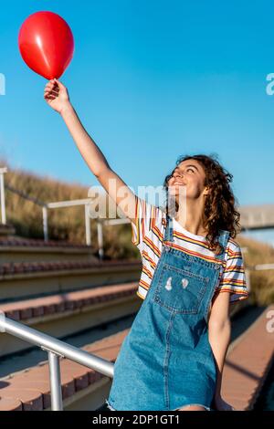 Junge Frau Holding roten ballon Stockfoto