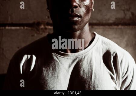 Sportsperson, der bei Sonnenuntergang gegen die graue Wand steht Stockfoto