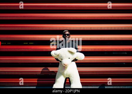 Portrait von coolen jungen Mann mit großer Teddybär Stockfoto