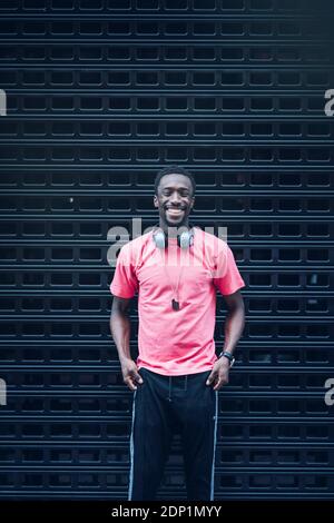 Porträt eines lachenden Mannes mit Kopfhörern in rosa T-Shirt Stockfoto