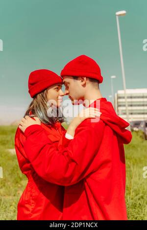 Junges Paar mit roten Overalls und Hüten, die Kopf zu stehen Kopf, der sich anschaut Stockfoto