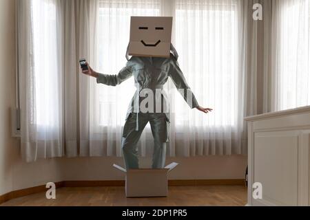 Frau mit einem Karton auf dem Kopf mit Gesicht und stehend In Box Stockfoto