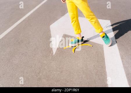 Mädchen tritt auf Bananenschale auf einer Straße Stockfoto