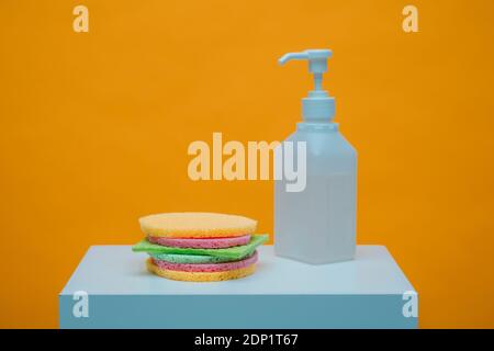 Schwämme und Schwammtuch in Form eines Burgers reinigen Durch Sprühflasche mit Desinfektionsmittel Stockfoto