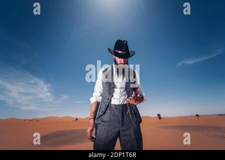 Mann mit Bart und Hut in den Dünen der Wüste von Marokko das mal prüfen. Stockfoto