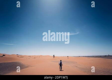 Einsamer Mann mit Hut Wandern in den Dünen der Wüste von Marokko Stockfoto