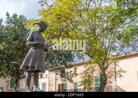 Llucmajor, Spanien; dezember 17 2020: Öffentliche Bronzeskulptur namens Espigolera, die ein Mädchen mit Spitzen in ihren Händen darstellt Stockfoto