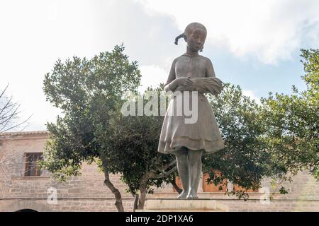 Llucmajor, Spanien; dezember 17 2020: Öffentliche Bronzeskulptur namens Espigolera, die ein Mädchen mit Spitzen in ihren Händen darstellt Stockfoto