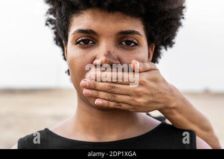 Hand in den Mund der Frau von einer anderen Frau, close-up Stockfoto
