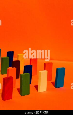 Mehrfarbiger rechteckiger Spielzeugblock vor orangefarbenem Hintergrund Stockfoto