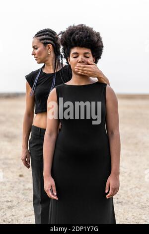 Hand in den Mund der Frau von einer anderen Frau Stockfoto