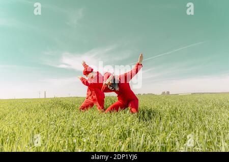 Junges Paar trägt rote Overalls und Hüte Durchführung auf ein Ein Stockfoto