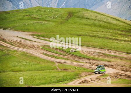 SUV-Auto auf Off-Road in Frühling hügelige Landschaft. Drive And Travel Konzept Stockfoto