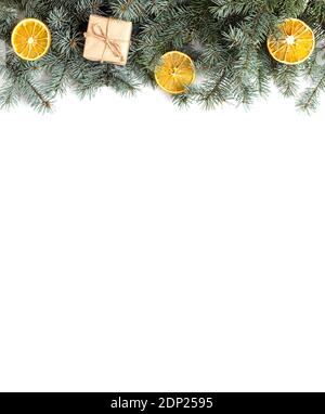 Weihnachtliche Umrandung mit Tannenzweigen, Geschenken und getrockneten Orangen auf weißem Hintergrund. Weihnachtskonzept. Vertikale Ausrichtung. Blick von oben. Stockfoto