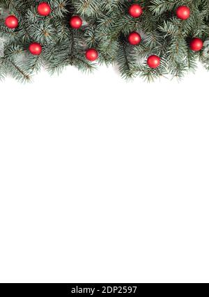Weihnachtliche Umrandung mit Tannenzweigen und roten Kugeln auf weißem Hintergrund. Weihnachtsschmuck. Speicherplatz kopieren. Draufsicht, flach liegend. Vertikale Ausrichtung Stockfotografie