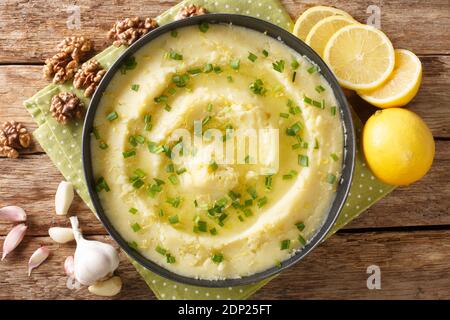 Delicious Greek Skordalia made from mashed potatoes with garlic, lemon, nuts and olive oil close-up in a plate on the table. horizontal top view from Stock Photo