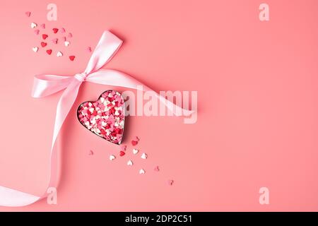 Herz mit rosa Schleife auf rosa Hintergrund. Stockfoto