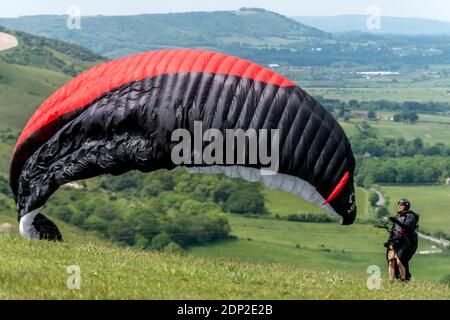 Gleitschirme fliegen von oben von Devil's Dyke in den Sussex Weald an einem schönen Nachmittag. Stockfoto