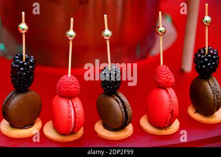 Beerenstäbchen eingebettet in feine französische Macarons Stockfoto