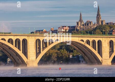 Am frühen Morgen Rower in Skiff am Potomac River, Key Bridge und Georgetown University im Hintergrund, Washington DC, USA. Stockfoto