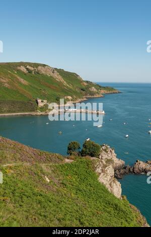 Sommerzeit, Sonnentag, Bouley Bay, Jersey, Kanalinseln. Blick vom Klippenpfad. Pier, Fort, Küste. Hochformat. Stockfoto