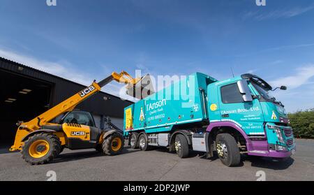 Beladen von Bohnen für Tierfutter in einen Wagen aus einem Hofladen mit einem JCB Loadall. North Yorkshire, Großbritannien. Stockfoto