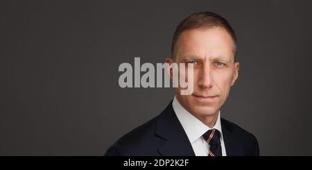 Gepflegtes Männerporträt mittleren Alters vor dunklem Hintergrund. Porträt des Geschäftsmannes. Kopfschuss für Männer. Stockfoto