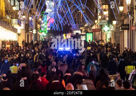 Madrid, Spanien. Dezember 2020. Ein Polizeiauto patrouilliert in der Preciados Straße in der Nähe des Sol Platzes voller Menschen. Während der Weihnachtszeit wurde von der Polizei ein spezielles Sicherheitsgerät eingerichtet, um die Maßnahmen gegen die Ausbreitung des Coronavirus zu gewährleisten (COVID-19). Quelle: Marcos del Mazo/Alamy Live News Stockfoto