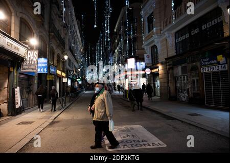 Madrid, Spanien. Dezember 2020. Die Menschen gehen unter den Weihnachtslichtern in der Nähe des Sol Square spazieren. Während der Weihnachtszeit wurde von der Polizei ein spezielles Sicherheitsgerät eingerichtet, um die Maßnahmen gegen die Ausbreitung des Coronavirus zu gewährleisten (COVID-19). Quelle: Marcos del Mazo/Alamy Live News Stockfoto