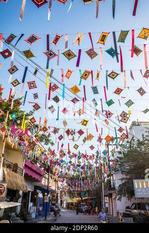 Ojos de Dios oder "Gottes Auge", ein lokales Symbol und Handwerk der indigenen Huichol-Kultur hängen von Drähten über den Straßen von Sayulita, Nayarit, Mexiko Stockfoto