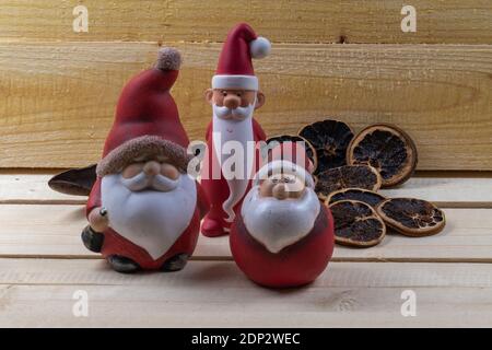 Rote Weihnachtsmänner auf rustikalen Holzbrettern als Weihnachtsschmuck. Stockfoto