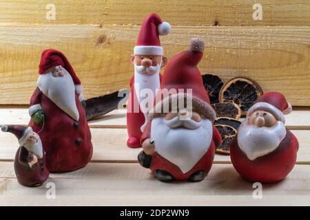 Rote Weihnachtsmänner auf rustikalen Holzbrettern als Weihnachtsschmuck. Stockfoto