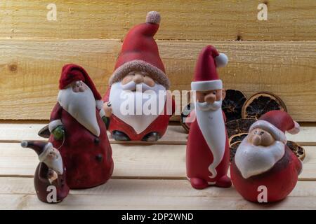 Rote Weihnachtsmänner auf rustikalen Holzbrettern als Weihnachtsschmuck. Stockfoto