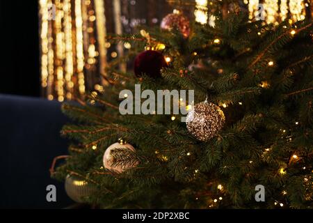 Neujahr 2021. Weihnachten schöne Lichter Bokeh auf dunklem Gold Hintergrund. Defokussed Lights. Weihnachtsbaum Spielzeug. Goldenes abstraktes Blinken verschwommen. Stockfoto