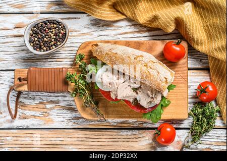 Sandwich mit hausgemachter Leberpastete, Rucola, Tomate, Ei und Kräutern. Weißer Holzhintergrund. Draufsicht. Stockfoto