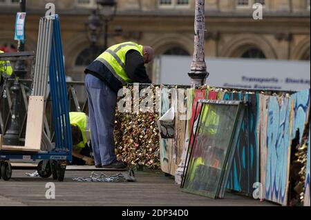 Stadtangestellte entfernen die Barrieren mit Liebesvorhängeschlössern am 1. Juni 2015 in Paris, Frankreich. Gelbe Beamte waren am frühen Montagmorgen auf der berühmten Pont des Arts der Stadt unterwegs und bewaisten Schneideausrüstung, um die Vorhängeschlösser zu befreien, während eine Handvoll neugieriger Touristen sich ansahen. Paris, weltweit bekannt als die Stadt der Romantik, begann am Montag den herzzerreißenden Prozess der Entfernung von fast einer Million Liebesschlösser, Vorhängeschlösser, die von verliebten Paaren an die Brücken der Stadt gekettet wurden. Foto von Thierry orban/ABACAPRESS.COM Stockfoto