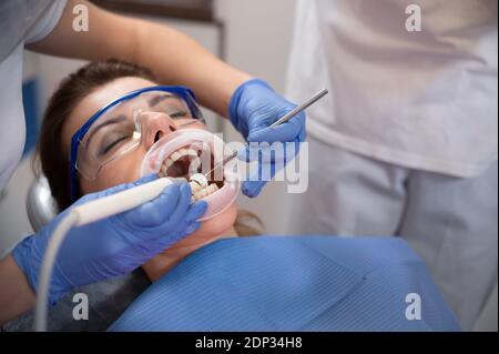 Zahnarzt, der die Zähne eines Patienten im Zahnarztbüro untersucht.Frau, die Zähne hat Bei Zahnärzten untersucht Stockfoto