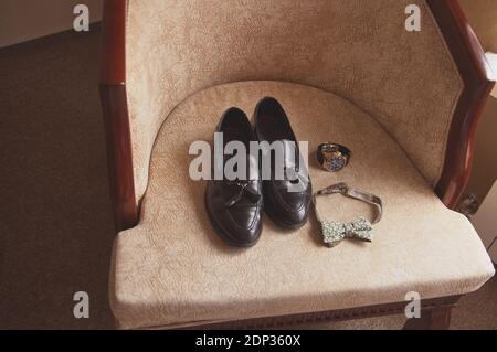 Hochzeit Herrenschuhe auf einem Sessel mit Uhr und Schleife Krawatte Stockfoto