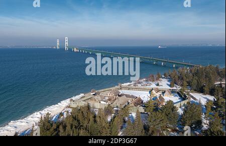 Luftaufnahme der Geraden von Mackinaw, mit Fort Michilimackinac im Vordergrund und der Mackinac Bridge im Hintergrund, und einem Frachter Stockfoto