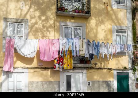 Setubal, Portugal - 18. Dezember 2020: Kleidung, die in den engen Gassen zum Trocknen hängt Stockfoto