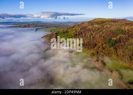 Luftaufnahme mit Blick auf landwirtschaftliches Ackerland und ein Tal Gefüllt mit einer Nebeldecke (Wales, UK) Stockfoto