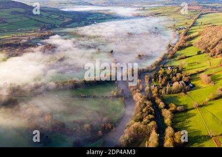 Luftaufnahme von Nebelflecken entlang eines Flusses in ländlicher Umgebung (River Usk, Powys, Wales) Stockfoto