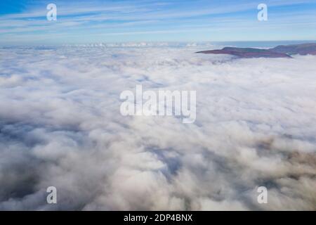 Luftaufnahme der Berge, die durch ein Meer von Nebel und niedrigen Wolken in einer ländlichen Umgebung stochen. (Wales) Stockfoto