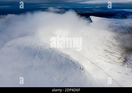 Luftaufnahme der Wolken, die über den Gipfel der schneebedeckten Berge.. Stockfoto