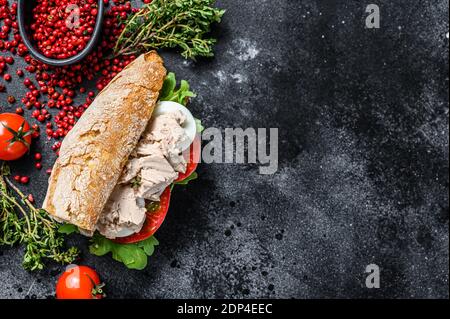 Ciabatta-Sandwich mit Leberpastete, Rucola, Tomate, Ei und Kräutern. Schwarzer Hintergrund. Draufsicht. Speicherplatz kopieren. Stockfoto