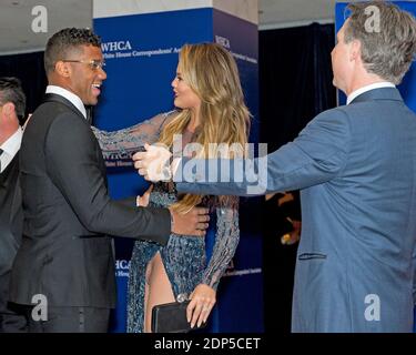 Chrissy Teigen begrüßt Seattle Seahawks Quarterback Russell Wilson, als sie am Samstag, den 25. April 2015, auf dem Roten Teppich zum Jahresessen der 2015 White House Correspondents Association im Washington Hilton Hotel ankommen. Verleger Jason Binn ist rechts.Foto von Ron Sachs/CNP/ABACAPRESS.COM Stockfoto