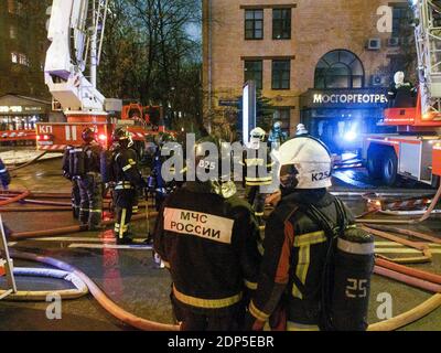 Feuerwehrleute und Rettungskräfte bereiten sich darauf vor, das Feuer zu löschen. Im 7. Stock eines Bürogebäudes in der Nähe des Zentrums von Moskau brach ein Großbrand aus. Das Feuer breitete sich auf das Dach aus und überdeckte eine Fläche von mehr als 300 Quadratmetern. 130 Menschen wurden aus dem Gebäude evakuiert, niemand wurde verletzt und die Brandursache ist noch unbekannt. Stockfoto